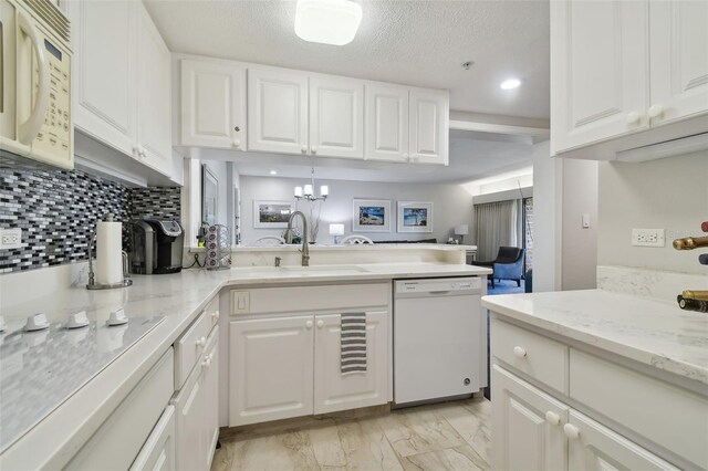 kitchen with white appliances, tasteful backsplash, white cabinetry, and sink