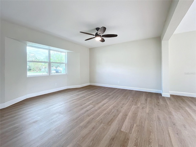 empty room with ceiling fan and light hardwood / wood-style floors