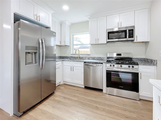 kitchen featuring light wood-type flooring, white cabinetry, and appliances with stainless steel finishes