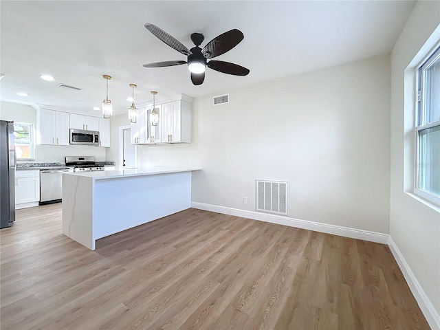 kitchen with white cabinets, kitchen peninsula, and appliances with stainless steel finishes