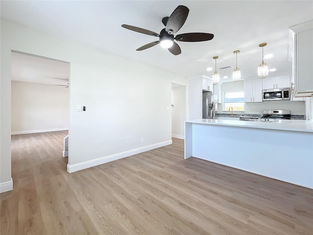 kitchen featuring appliances with stainless steel finishes, ceiling fan, decorative light fixtures, light hardwood / wood-style flooring, and white cabinets