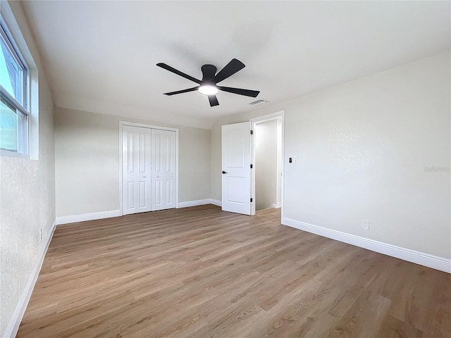 unfurnished bedroom featuring ceiling fan, a closet, and light hardwood / wood-style floors