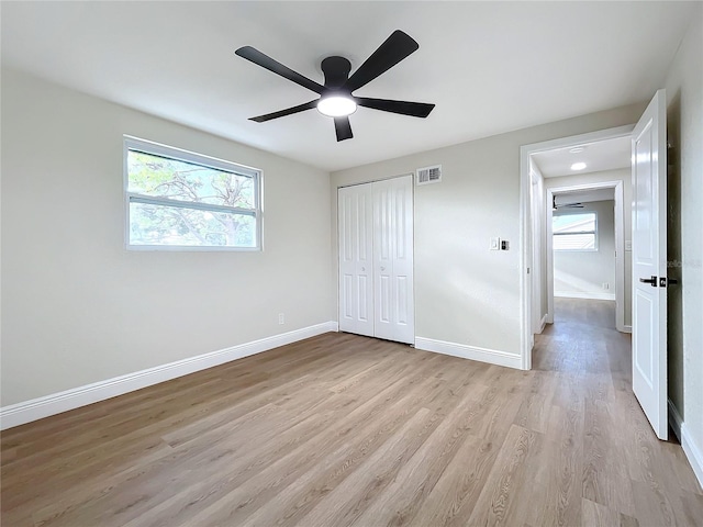 unfurnished bedroom with a closet, light hardwood / wood-style flooring, and ceiling fan