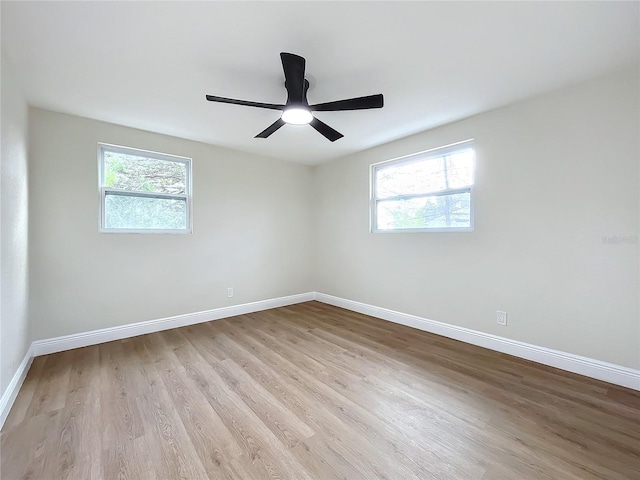 empty room featuring plenty of natural light, ceiling fan, and light hardwood / wood-style flooring