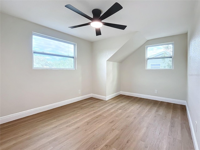 additional living space with ceiling fan, lofted ceiling, and light wood-type flooring