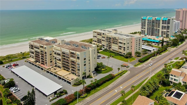 drone / aerial view with a water view and a beach view