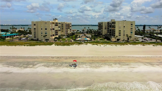 drone / aerial view with a water view, a view of the beach, and a city view