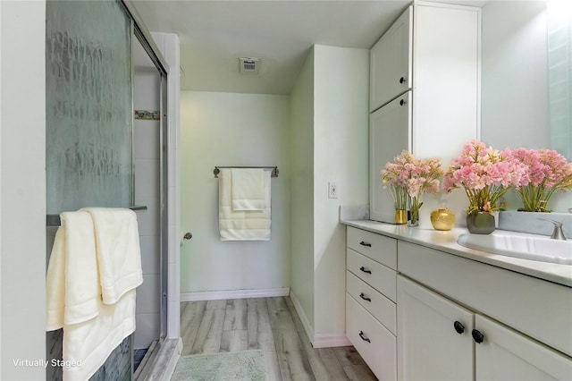 full bathroom with a shower stall, visible vents, wood finished floors, and vanity