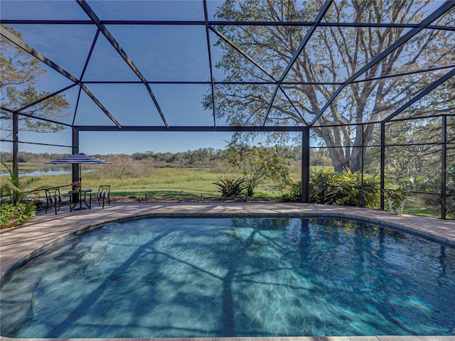 view of swimming pool with glass enclosure and a patio area