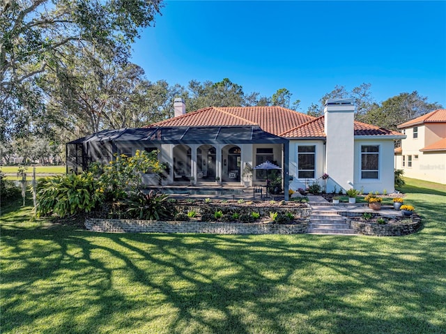 rear view of property with a lanai, a yard, and a patio