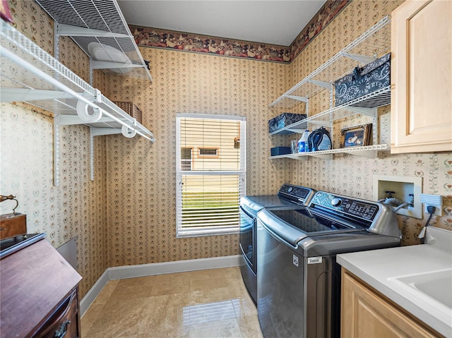 laundry area with cabinets, independent washer and dryer, light tile patterned floors, and sink