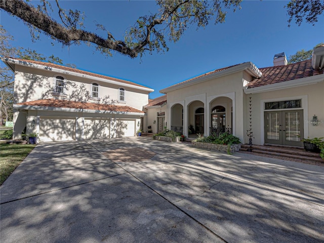 mediterranean / spanish-style house featuring french doors, a porch, and a garage