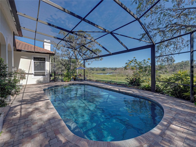 view of swimming pool featuring a patio area and a lanai