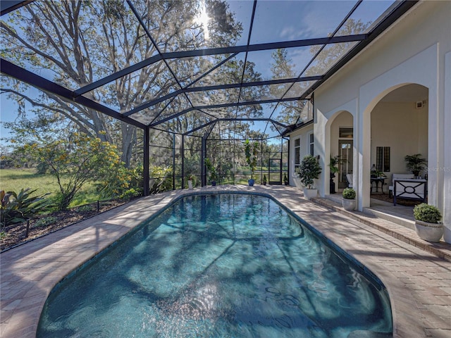 view of swimming pool with a patio and a lanai