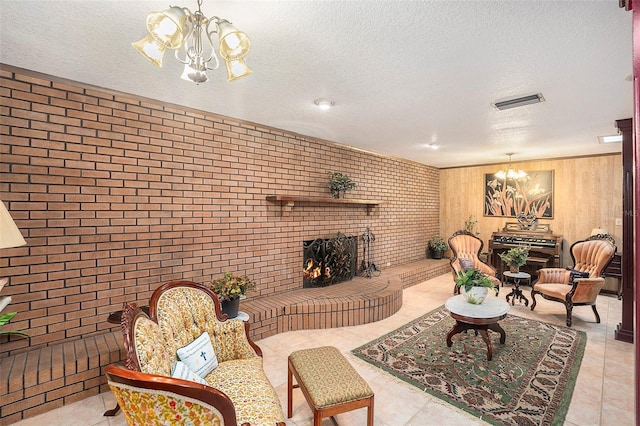 tiled living room featuring an inviting chandelier, brick wall, a brick fireplace, and a textured ceiling