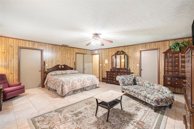 bedroom featuring light tile patterned flooring, crown molding, a textured ceiling, and wood walls