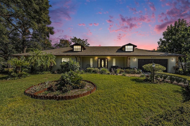 ranch-style home with a yard and a garage