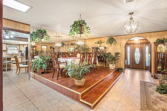 entrance foyer featuring an inviting chandelier, crown molding, and light tile patterned flooring