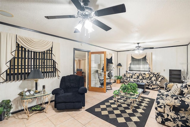 tiled living room with ceiling fan, ornamental molding, and a textured ceiling