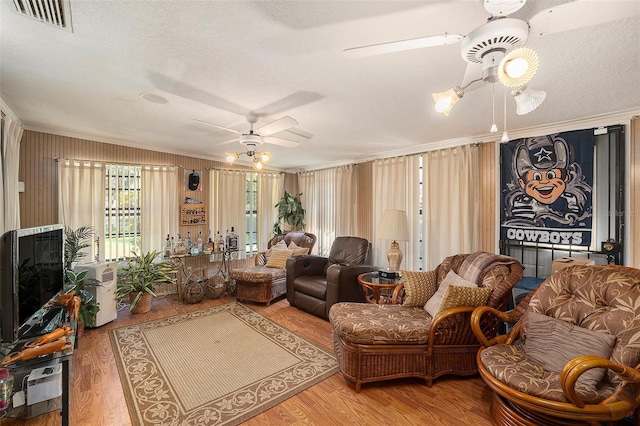 living room featuring crown molding, ceiling fan, and hardwood / wood-style flooring