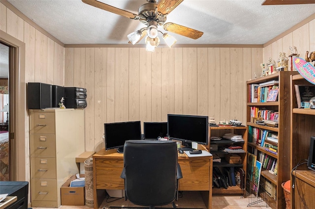 office space featuring ceiling fan, wooden walls, and a textured ceiling