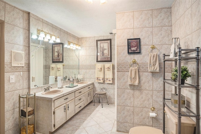 bathroom with tile walls, vanity, tile patterned floors, and a textured ceiling