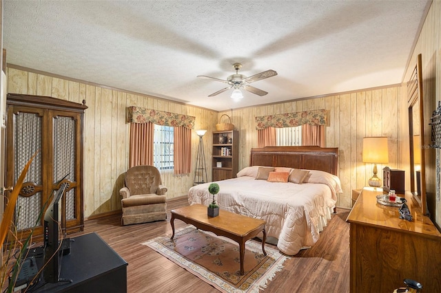 bedroom featuring crown molding, ceiling fan, hardwood / wood-style floors, and a textured ceiling