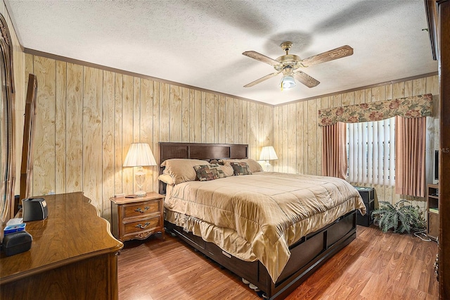 bedroom with crown molding, hardwood / wood-style floors, and a textured ceiling