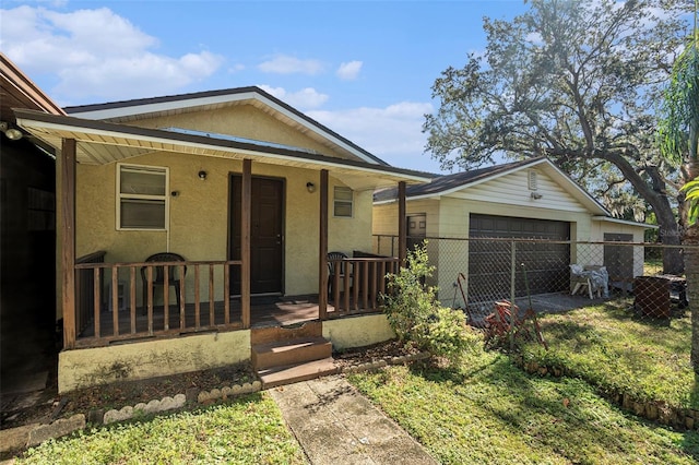 view of front of property featuring a garage, a front yard, an outbuilding, and covered porch