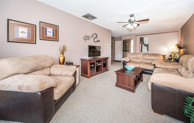 living room featuring ceiling fan, light carpet, and a textured ceiling