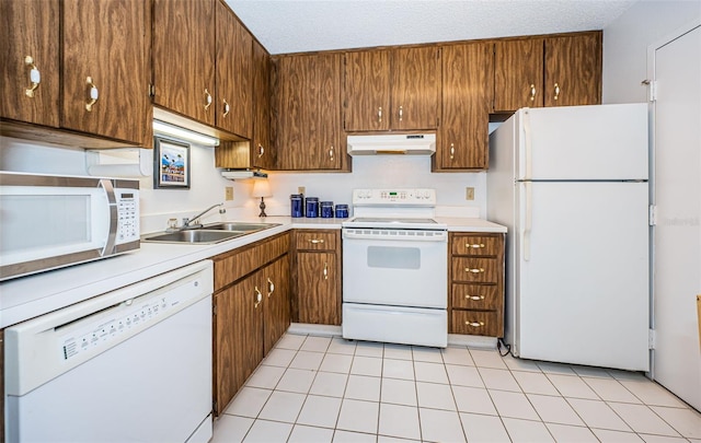 kitchen featuring a textured ceiling, white appliances, and sink