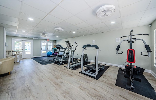 exercise room featuring a drop ceiling, light hardwood / wood-style flooring, and french doors