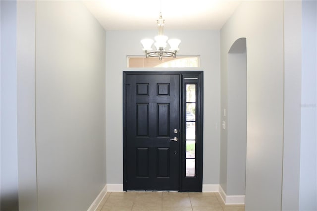 entryway featuring light tile patterned floors and a chandelier