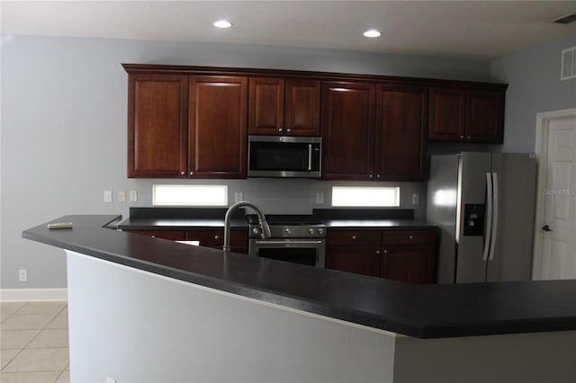 kitchen featuring kitchen peninsula, appliances with stainless steel finishes, and light tile patterned floors