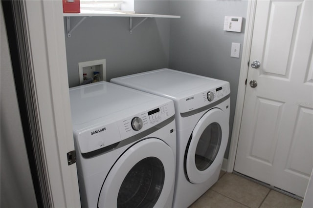 washroom with independent washer and dryer and light tile patterned floors