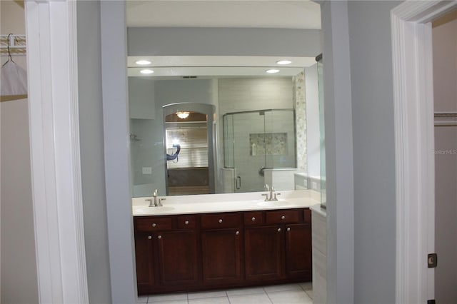 bathroom with tile patterned flooring, vanity, and a shower with door