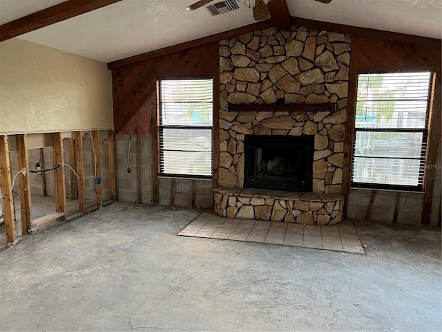 unfurnished living room with vaulted ceiling with beams, wooden walls, a fireplace, and a textured ceiling