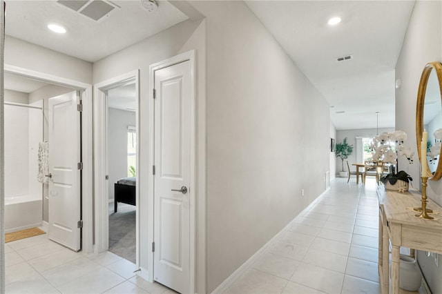 hall featuring a chandelier and light tile patterned floors