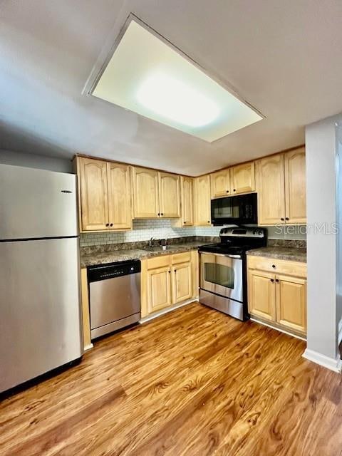 kitchen featuring light brown cabinetry, light wood-type flooring, and stainless steel appliances