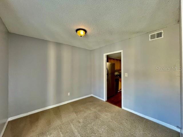 carpeted spare room with a textured ceiling