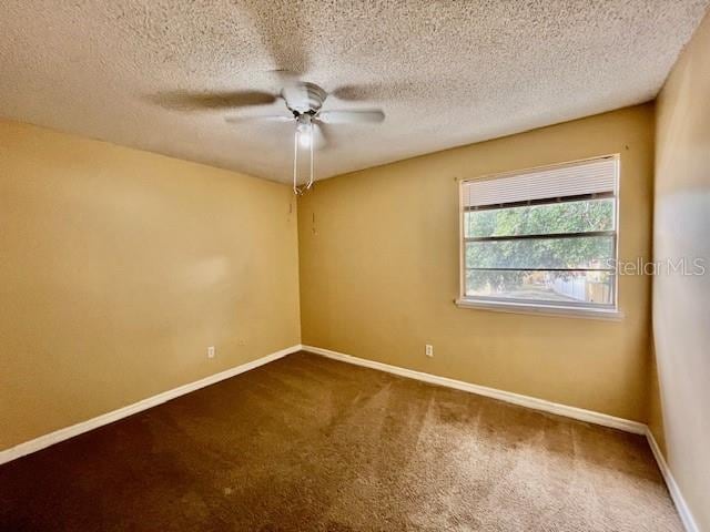 carpeted spare room with ceiling fan and a textured ceiling