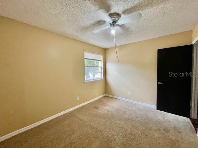 unfurnished room featuring carpet flooring, a textured ceiling, and ceiling fan