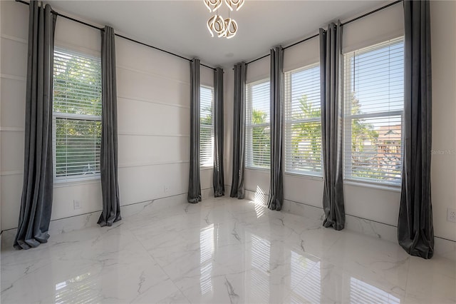 spare room featuring a notable chandelier