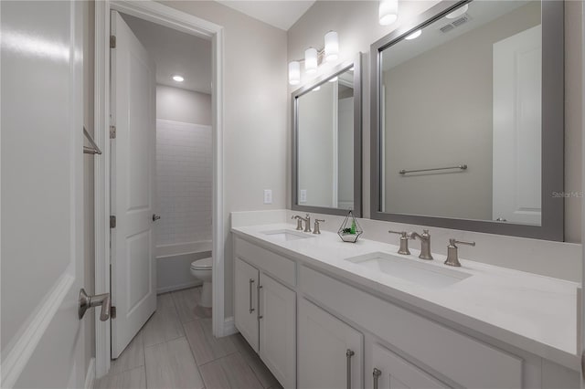 full bathroom featuring vanity, toilet, and tiled shower / bath