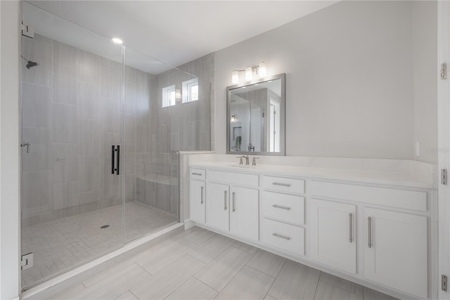 bathroom with vanity and a shower with door