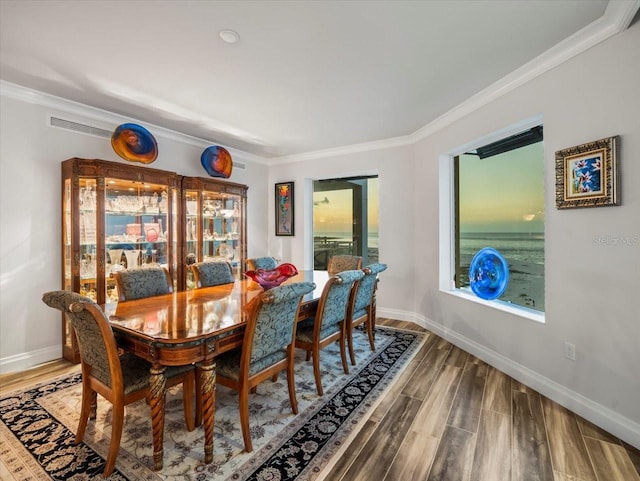 dining room with wood-type flooring and ornamental molding