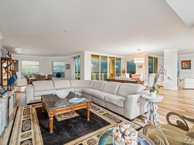 living room featuring a healthy amount of sunlight, crown molding, and light hardwood / wood-style flooring