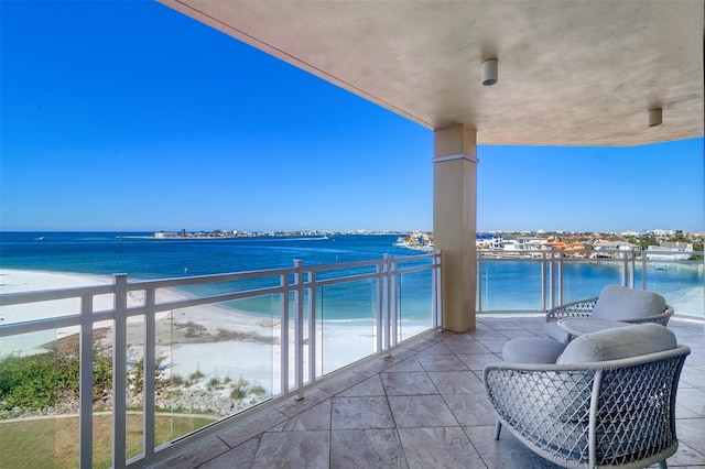 balcony featuring a water view and a beach view