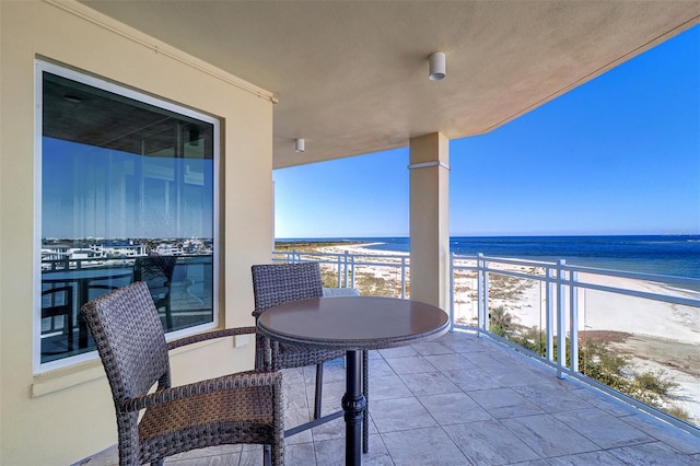 balcony featuring a beach view and a water view