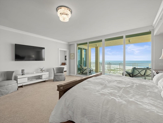 carpeted bedroom featuring access to exterior, a beach view, expansive windows, a water view, and ornamental molding